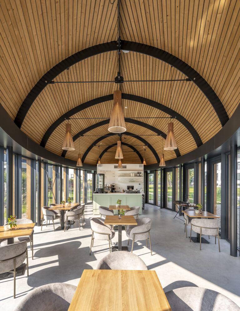 Modern café interieur met gewelfd houten plafond, glazen wanden en mintgroene bar met zitplaatsen.