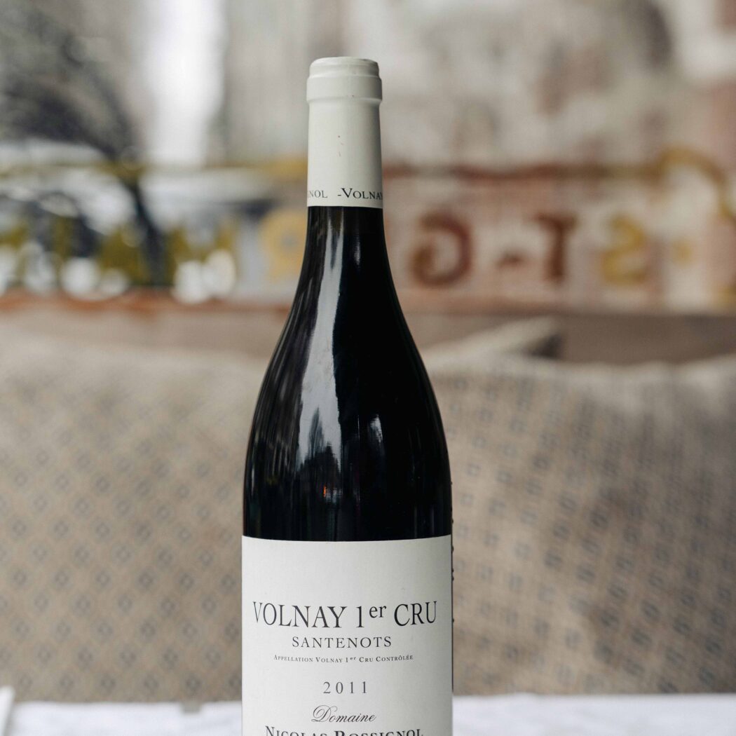 Fles rode wijn Volnay 1er Cru Santenots 2011 Domaine Nicolas Rossignol op zilveren onderzetter.