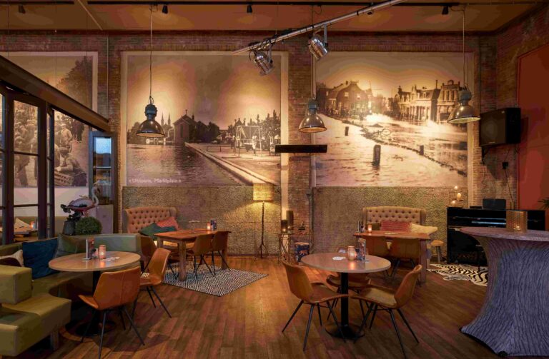 Industriële bar/restaurant met bakstenen muren, grote sepia wandfotos van Uithoorn, Marktplein en diverse zitjes.