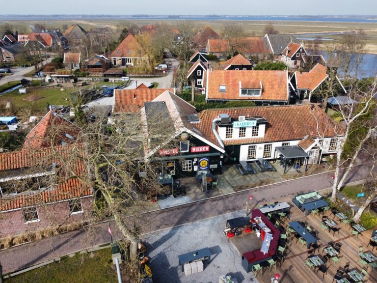 Traditioneel Nederlands dorp met rode dakhuisjes en het restaurant Kom In t Hof met ruim buitenterras aan het water.