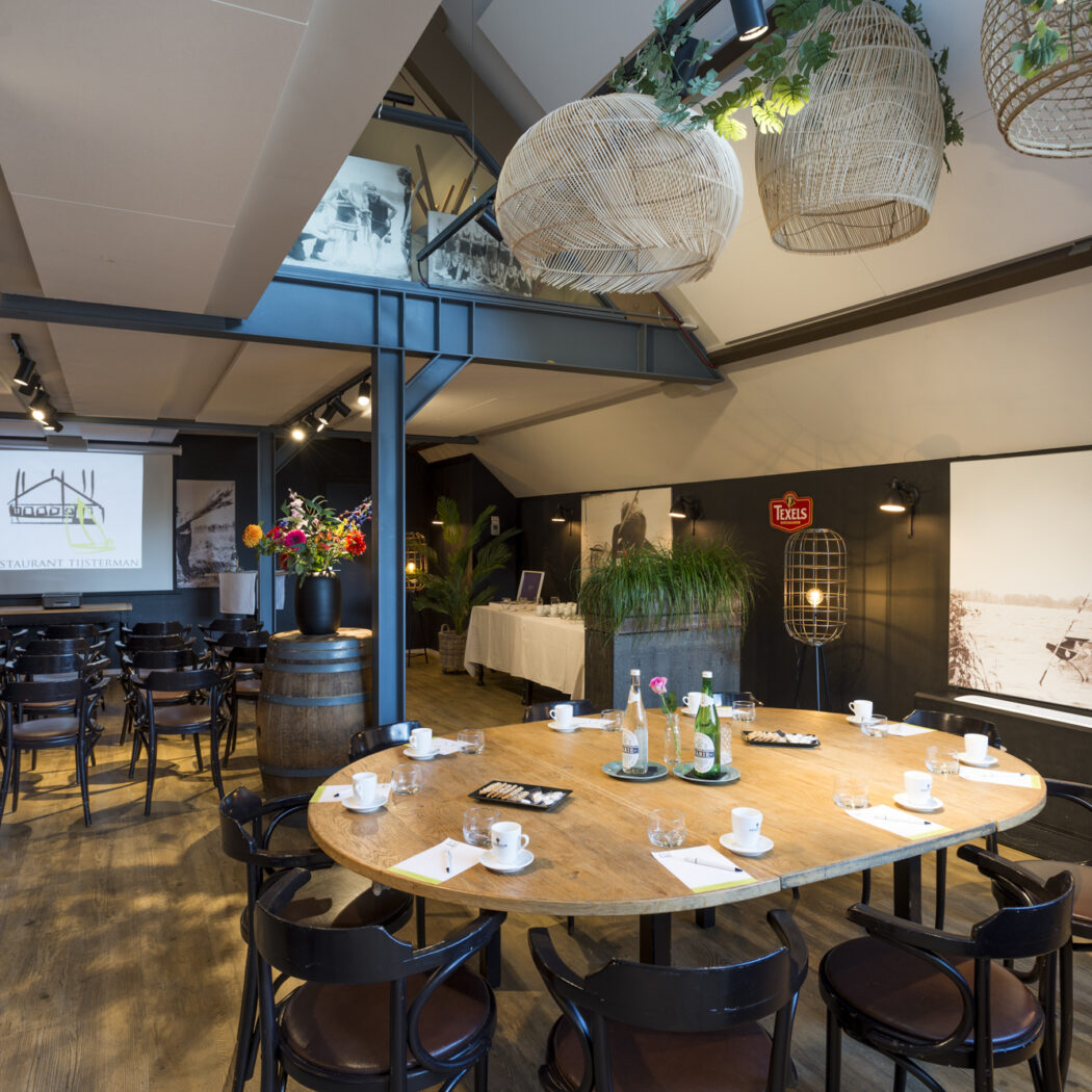 Moderne vergaderruimte met presentatiescherm RESTAURANT TIJSTERMAN, ovalen tafel, stoelen en Texels-logo.