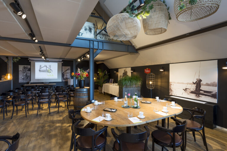 Moderne vergaderruimte met presentatiescherm RESTAURANT TIJSTERMAN, ovalen tafel, stoelen en Texels-logo.
