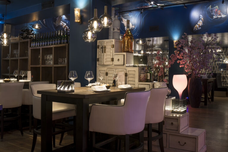 Stijlvol Japans restaurant met gedekte Yukio-San tafel, blauwe wand met koivissen en roze sfeerlicht.