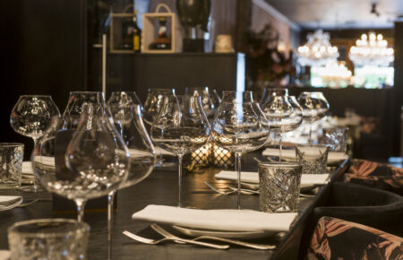 Gedeserveerde tafel met wijnglazen en bestek in chique restaurant.