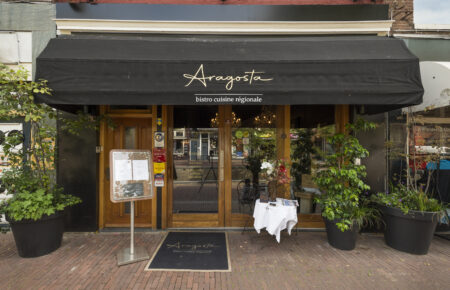 Restaurant Aragosta, bistro cuisine régionale.  Buitenterras met menu-bord.