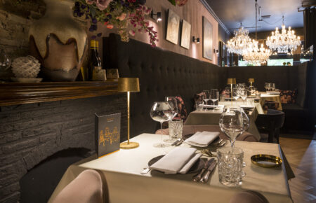 Restaurant interieur: gedekte tafels, fluwelen banken, kroonluchters.