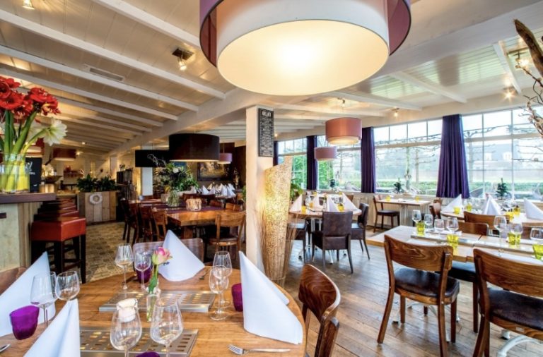 Sfeervol restaurantinterieur met gedekte houten tafels, paarse gordijnen voor grote ramen en een menubord met GELATO.
