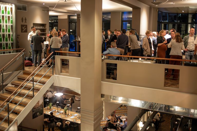 Gasten socialiseren op de hogere etage en dineren beneden in een sfeervolle, meerlaagse horecalocatie.