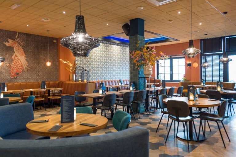Modern restaurant met houten tafels, bruine zitbanken, tegelpatroonbehang, koi vis art en zwarte kroonluchters.