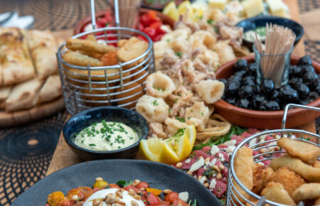 Grote borrelplank met burrata salade, gefrituurde calamari, olijven, vleeswaren en kaas.
